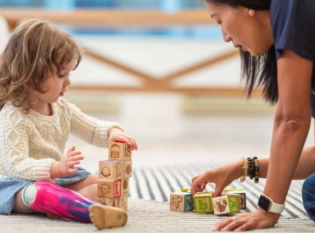 Paediatric Occupational Therapist with child participant building blocks.